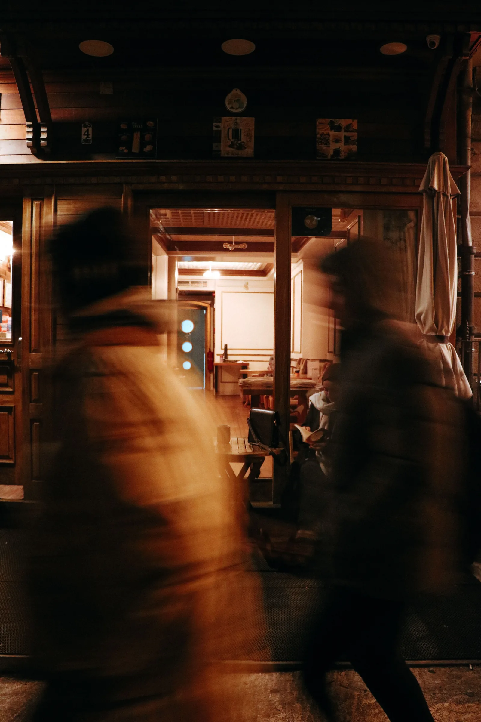 People entering a warm, wood-panelled room, in motion blur.