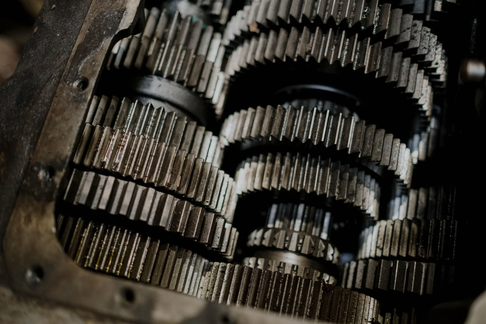 Rows of steel gears mesh tightly inside an open gearbox, each wheel turning against the next.