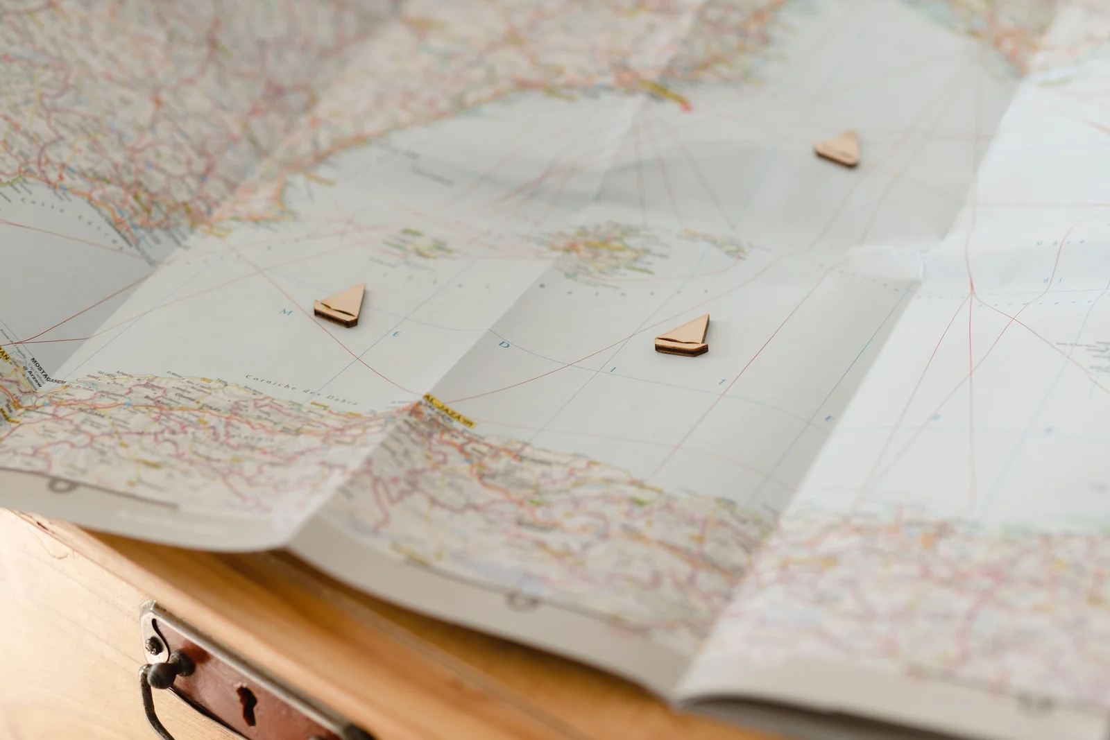 Small wooden markers placed at chosen points on an unfolded map lying on a table.