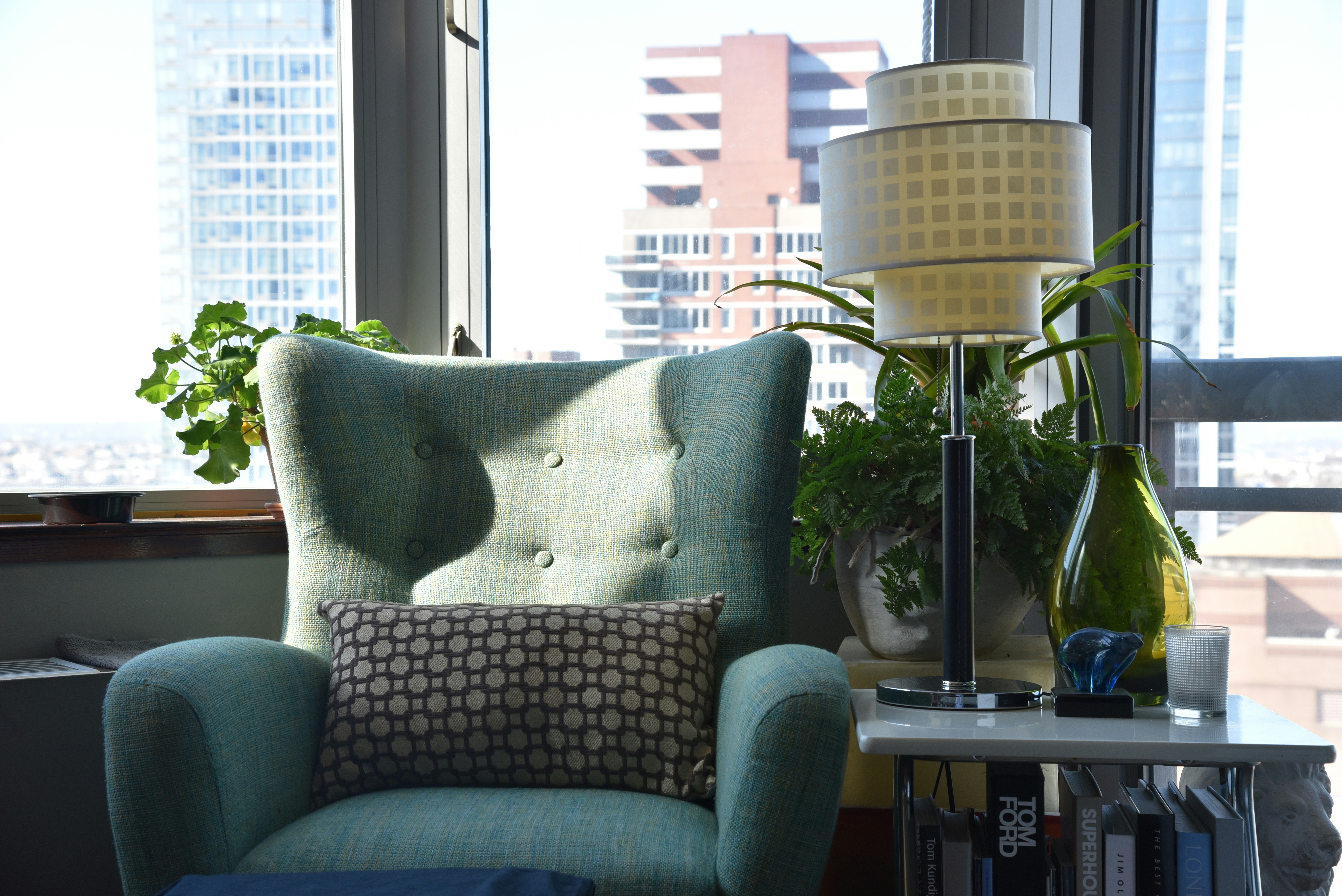 A quiet armchair by a city window.