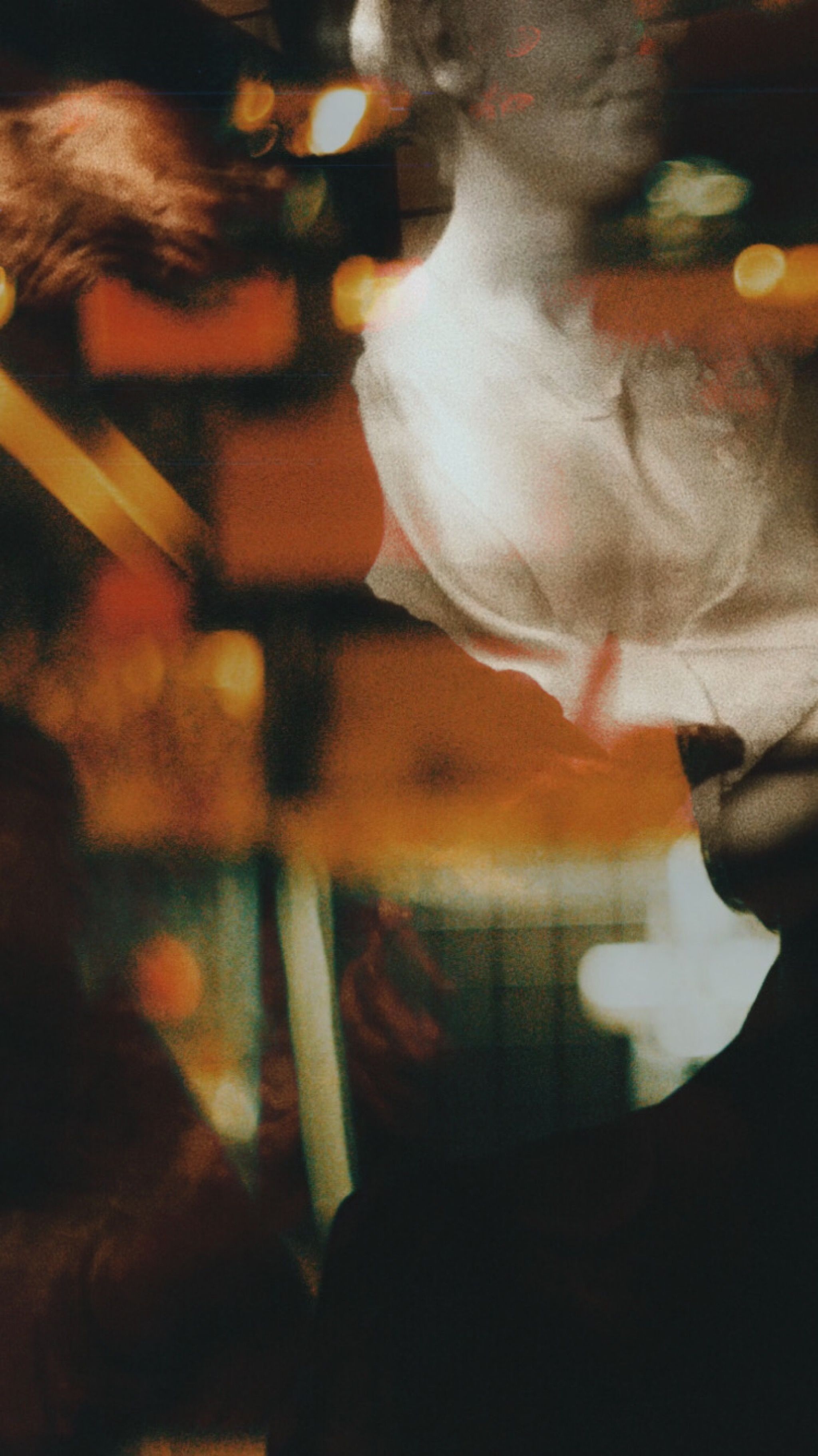 A person in a white shirt in a warm, softly lit room, caught in gentle motion blur.